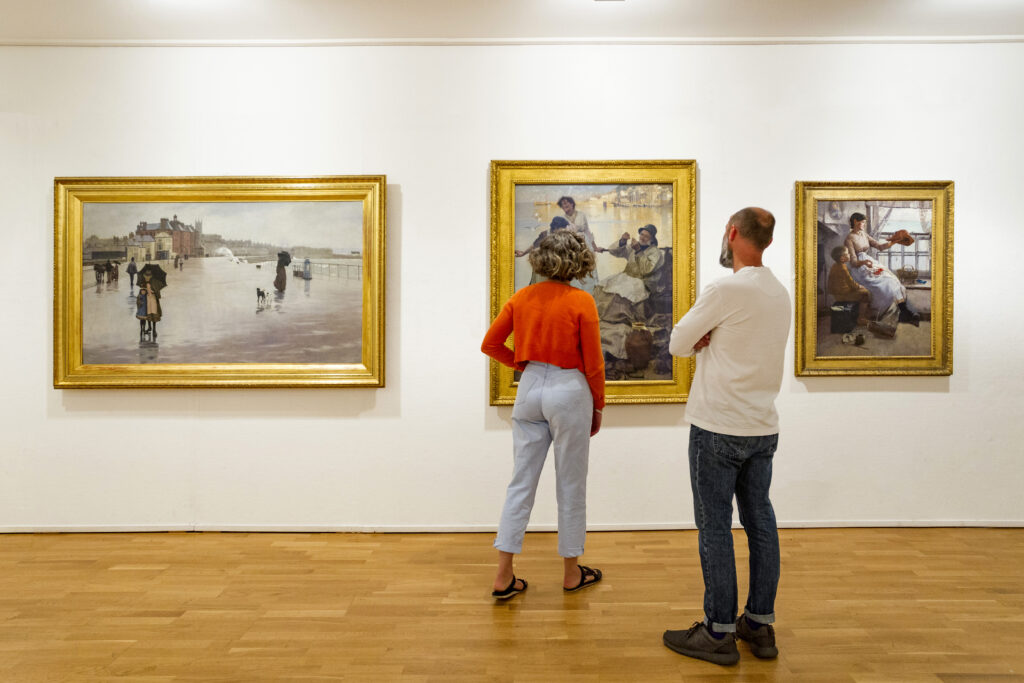 Visitors to Penlee House pause to look at a painting