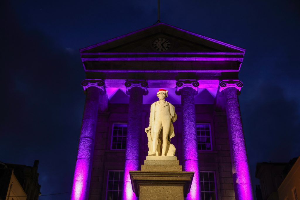 Humphry Davy Statue wearing a Christmas hat with the Market House lit up in the background